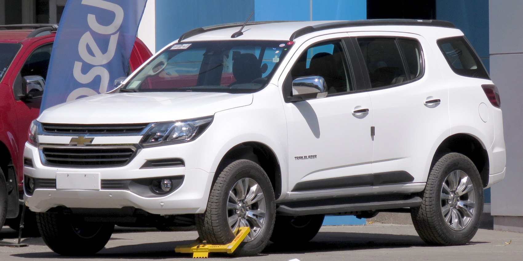 White mid-size SUV front and side view with alloy wheels and chrome mirrors