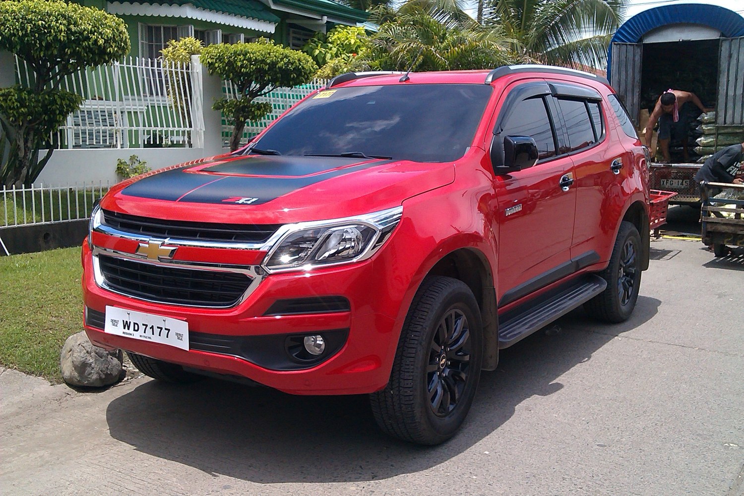 Red SUV with black hood accent and roof rails