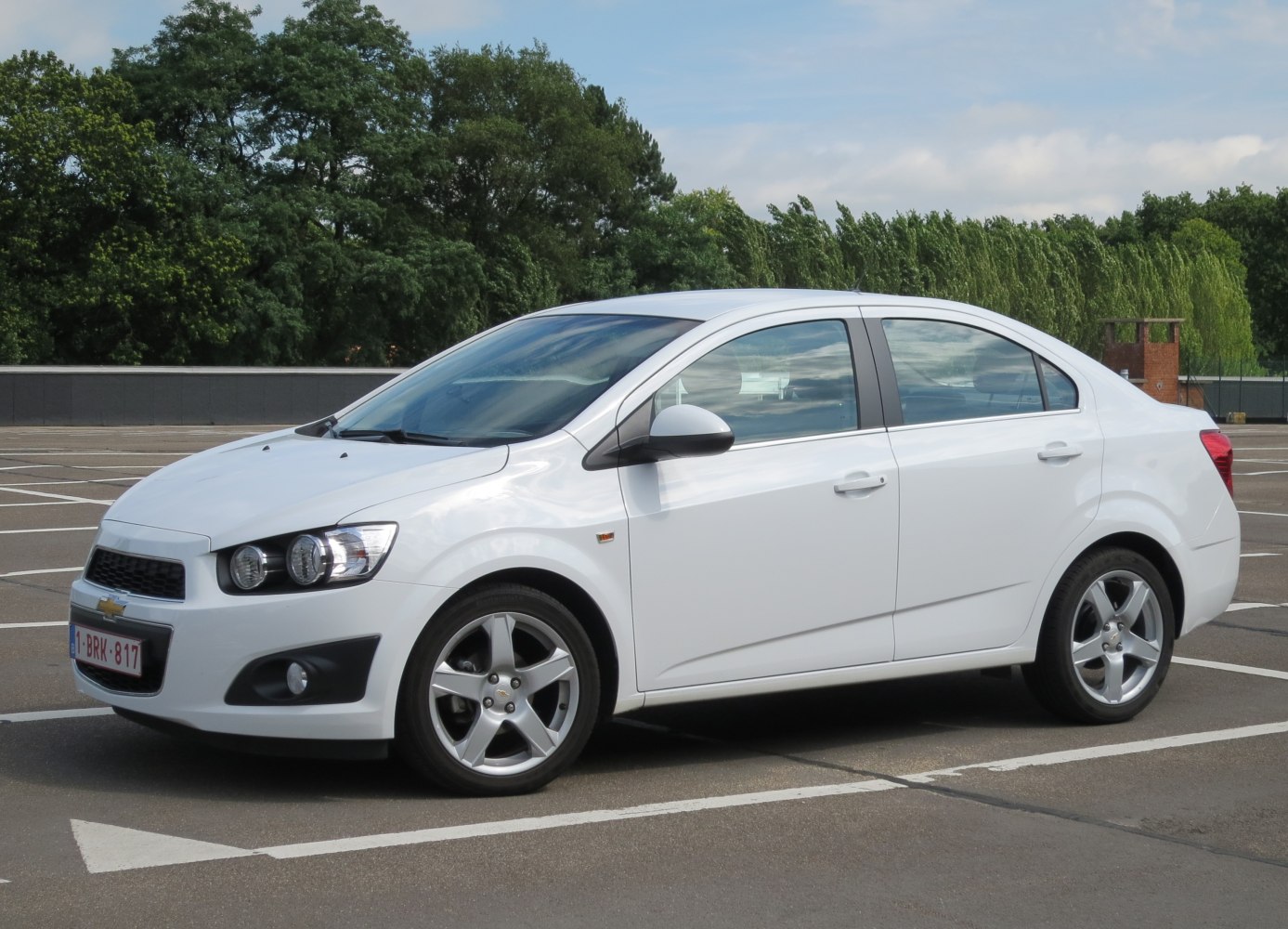 White compact sedan with alloy wheels and side profile view