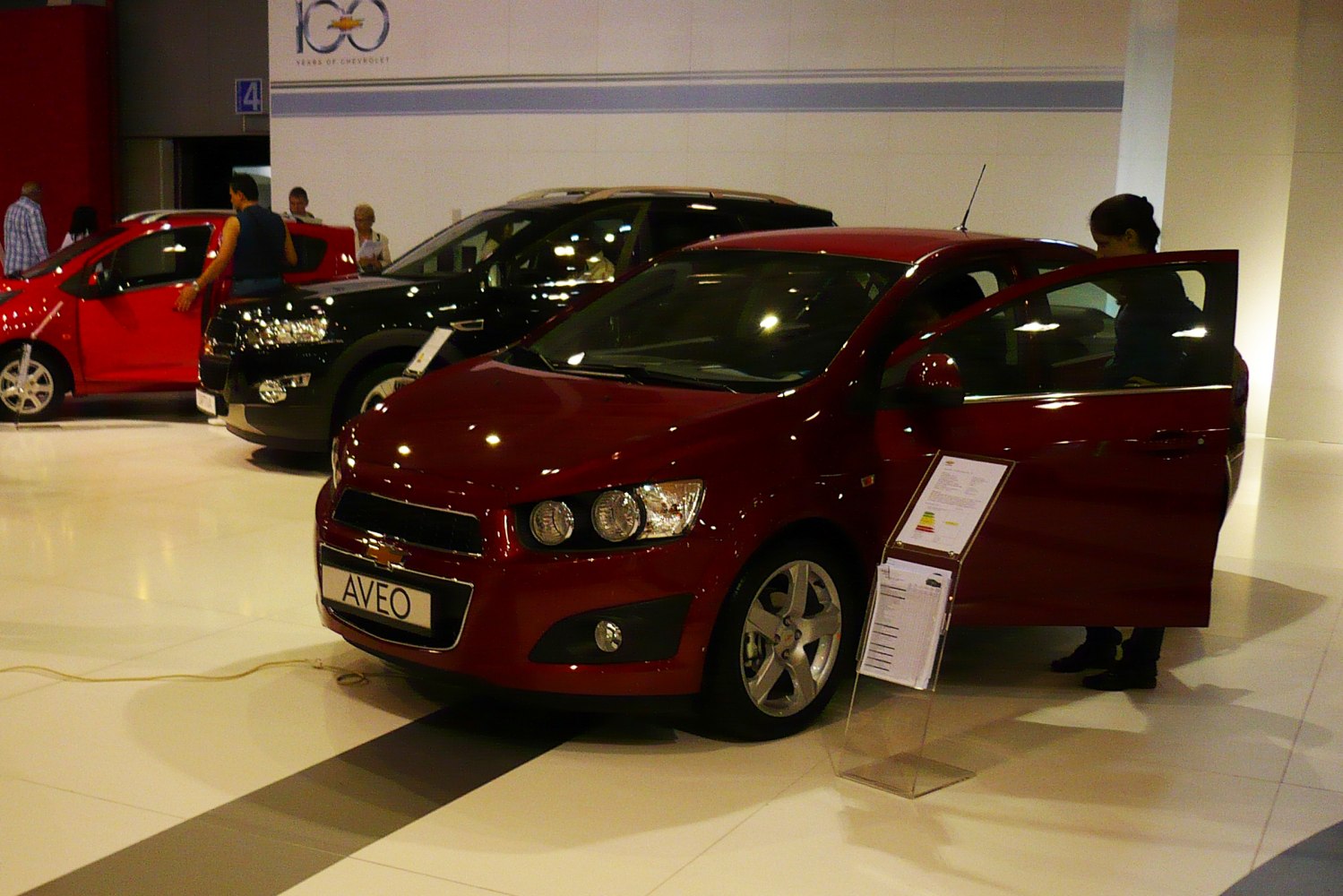 Front view of red compact sedan with round headlights and alloy wheels