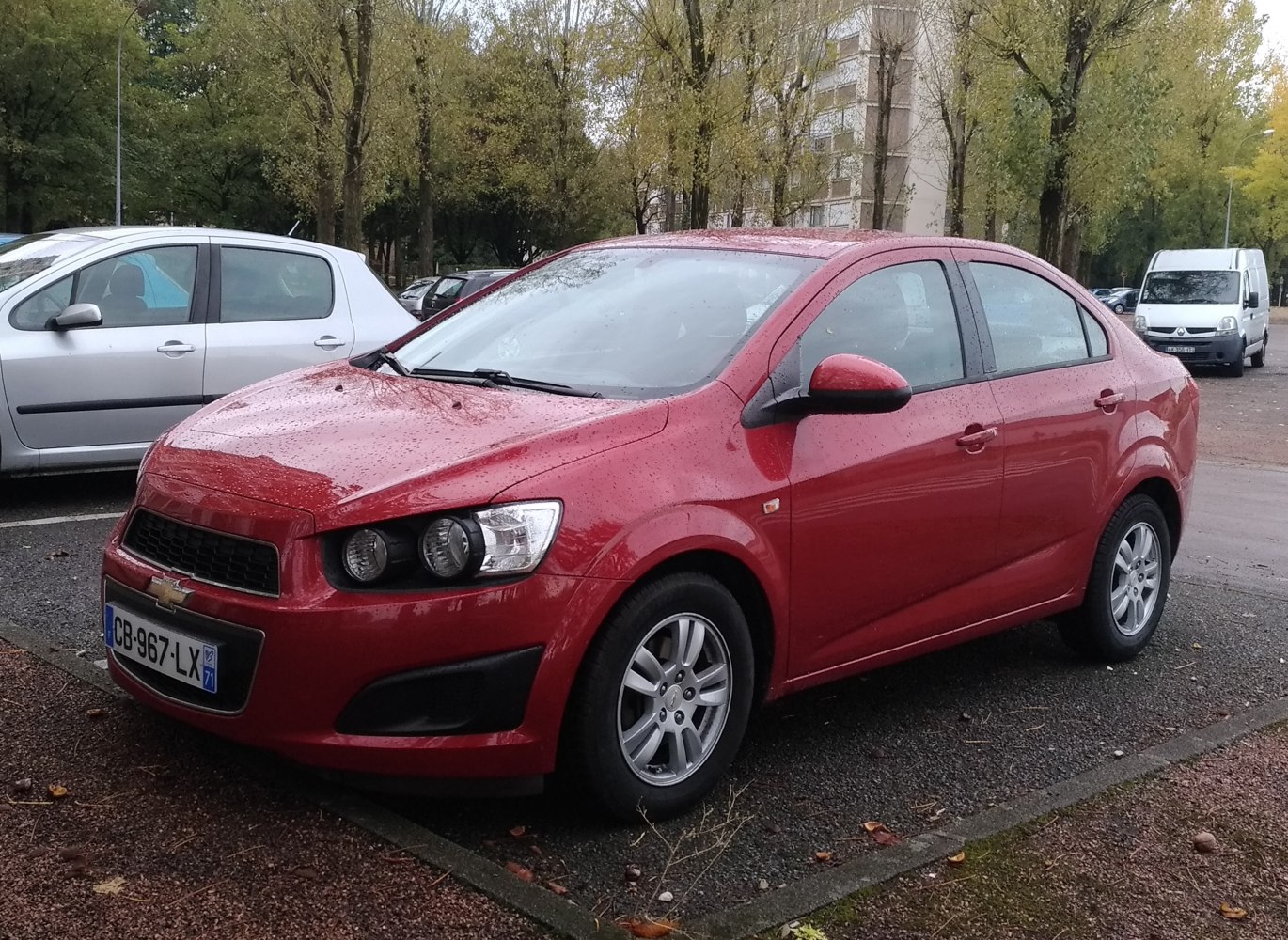 Front-side view of compact sedan with distinct headlights in rainy weather