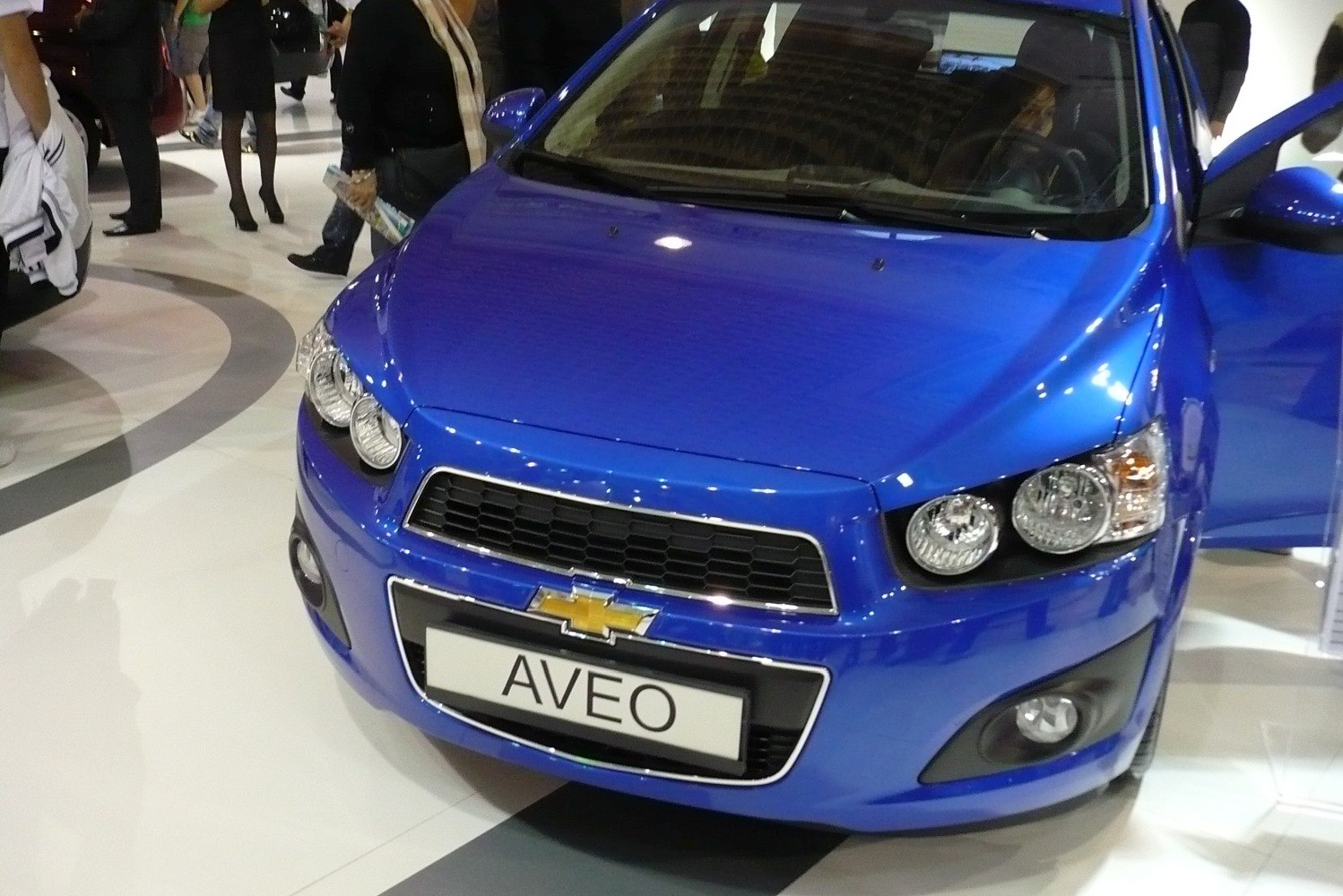 Front grille, headlights, and fog lamps of a blue compact hatchback