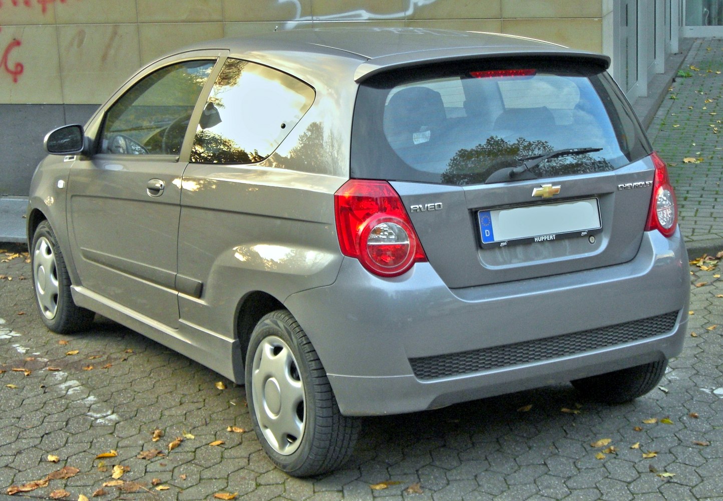 Rear view of a compact 3-door hatchback with prominent taillights and rear spoiler.