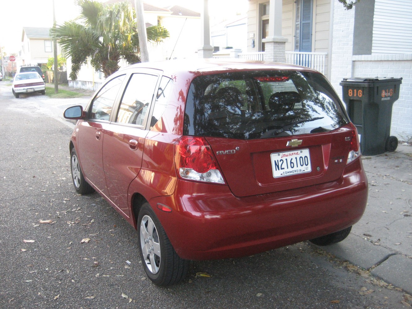 Rear view of a red hatchback with visible tail lights and rear window.