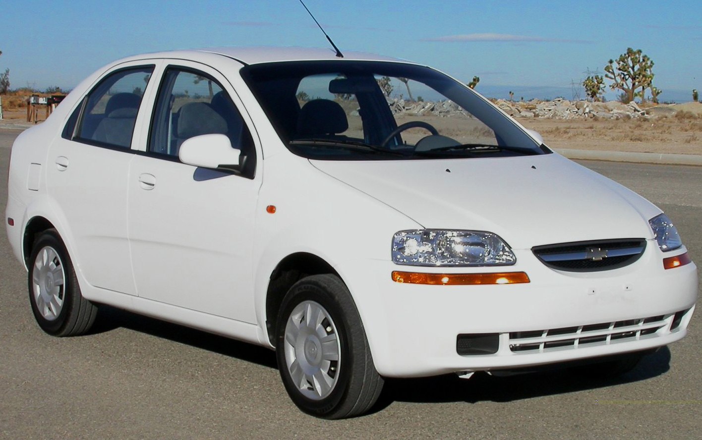 White compact sedan with clear headlights and side mirrors