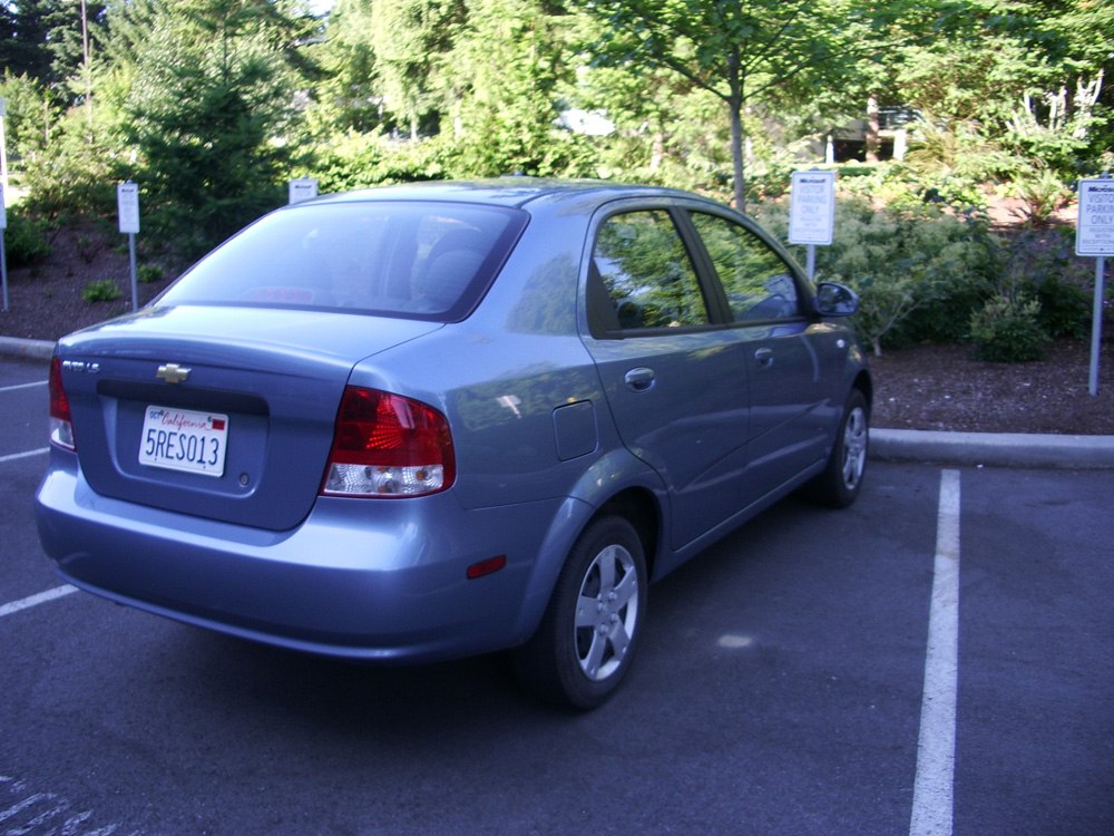 Rear side view of a compact sedan in a parking lot