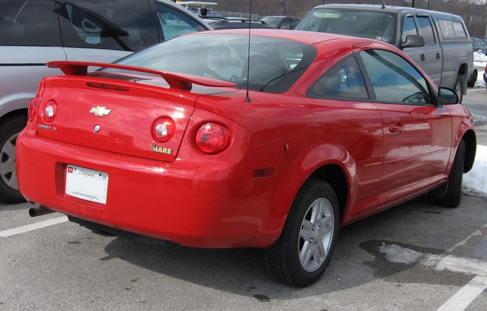 Rear view of red coupe with round taillights and spoiler