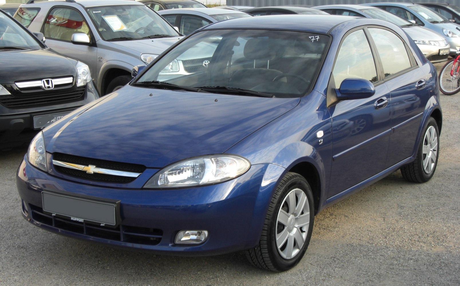 Blue mid-2000s hatchback compact car front and side view