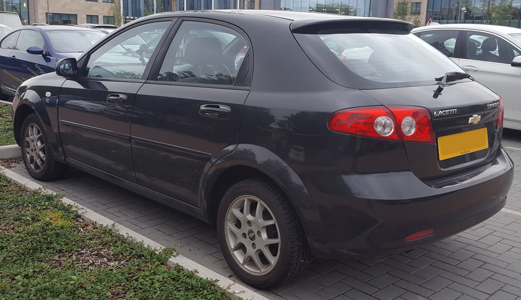 Rear side hatchback view with tail lights and alloy wheels