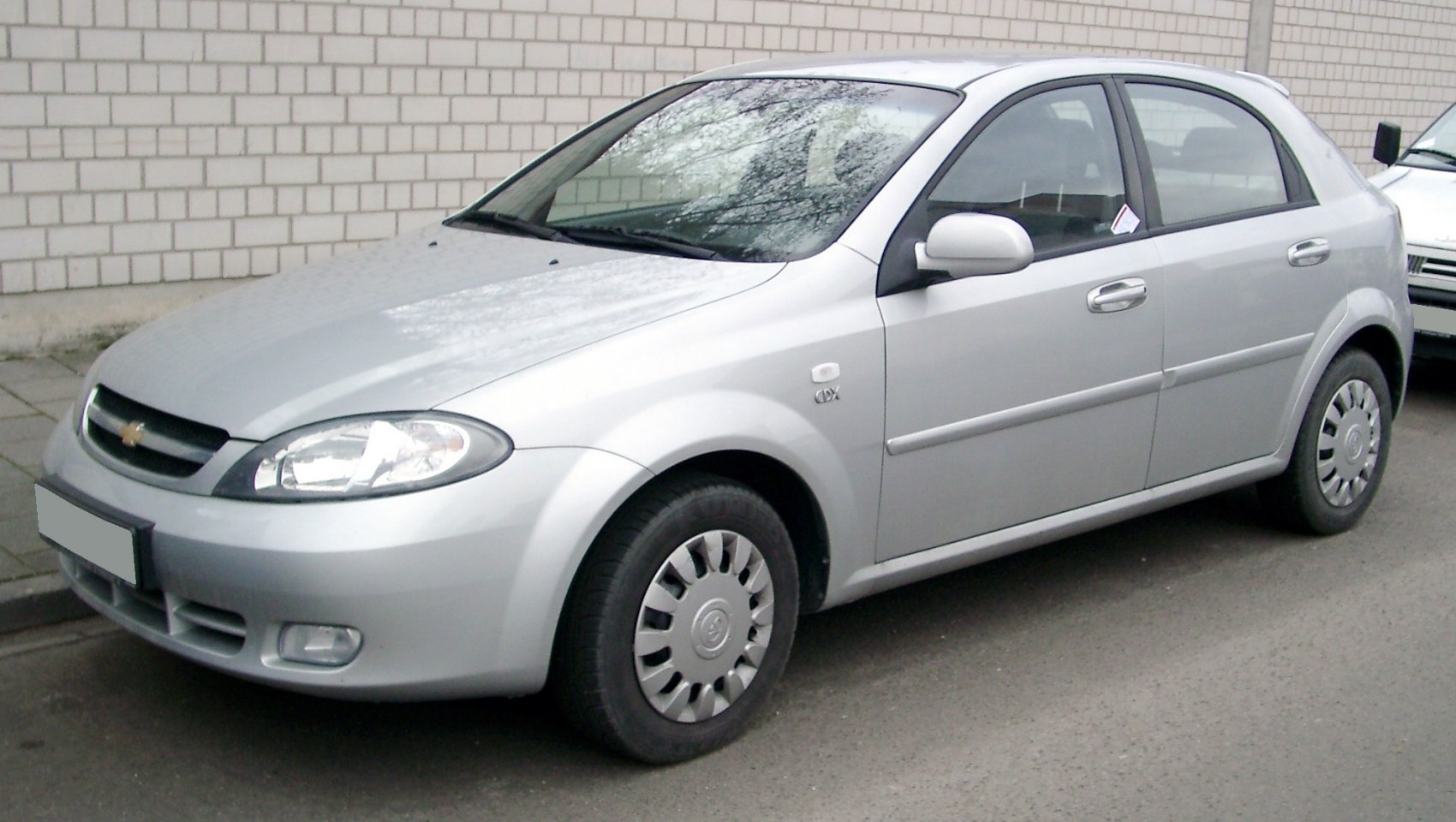 Silver hatchback showing front side profile and wheel design.