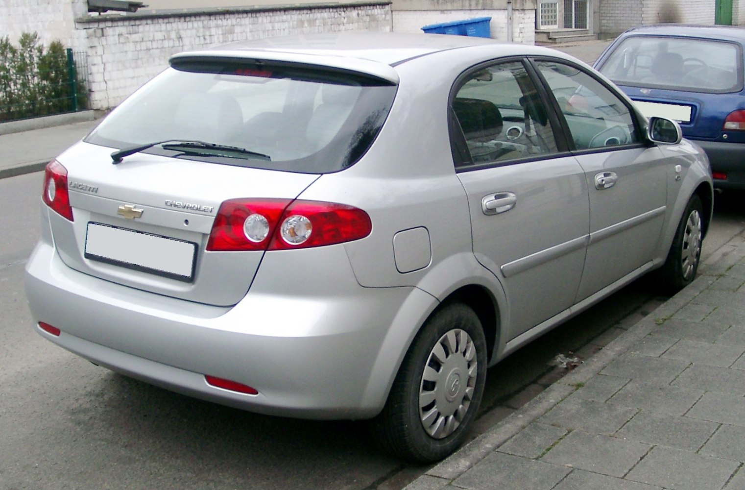 Rear and side view of a compact silver hatchback with distinct tail lights and rear wiper