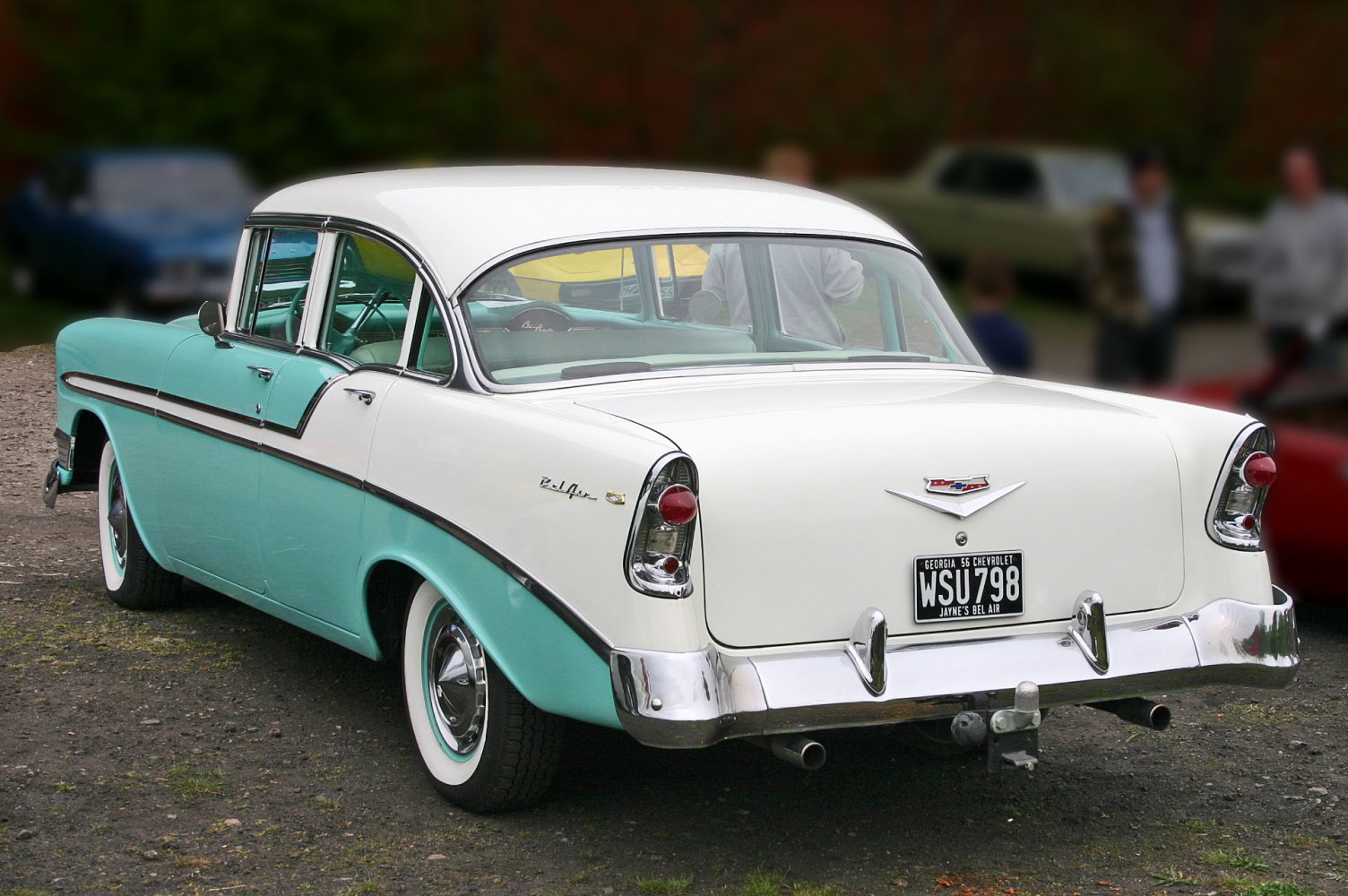 Vintage car rear with dual-tone paint, tailfins, and chrome bumper details