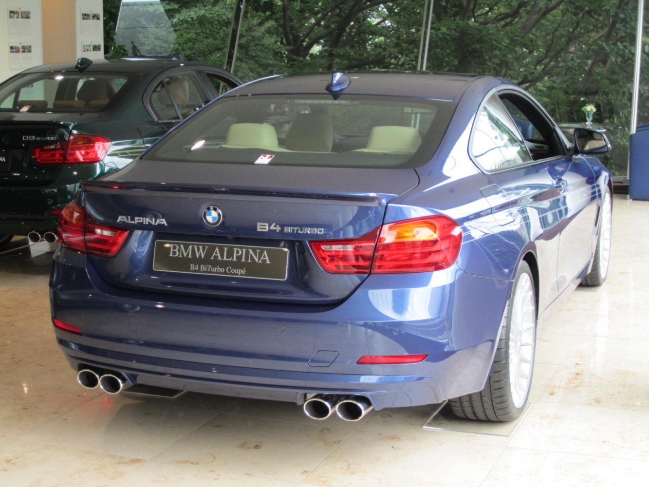 Blue luxury coupe rear with quad exhaust pipes and sleek design