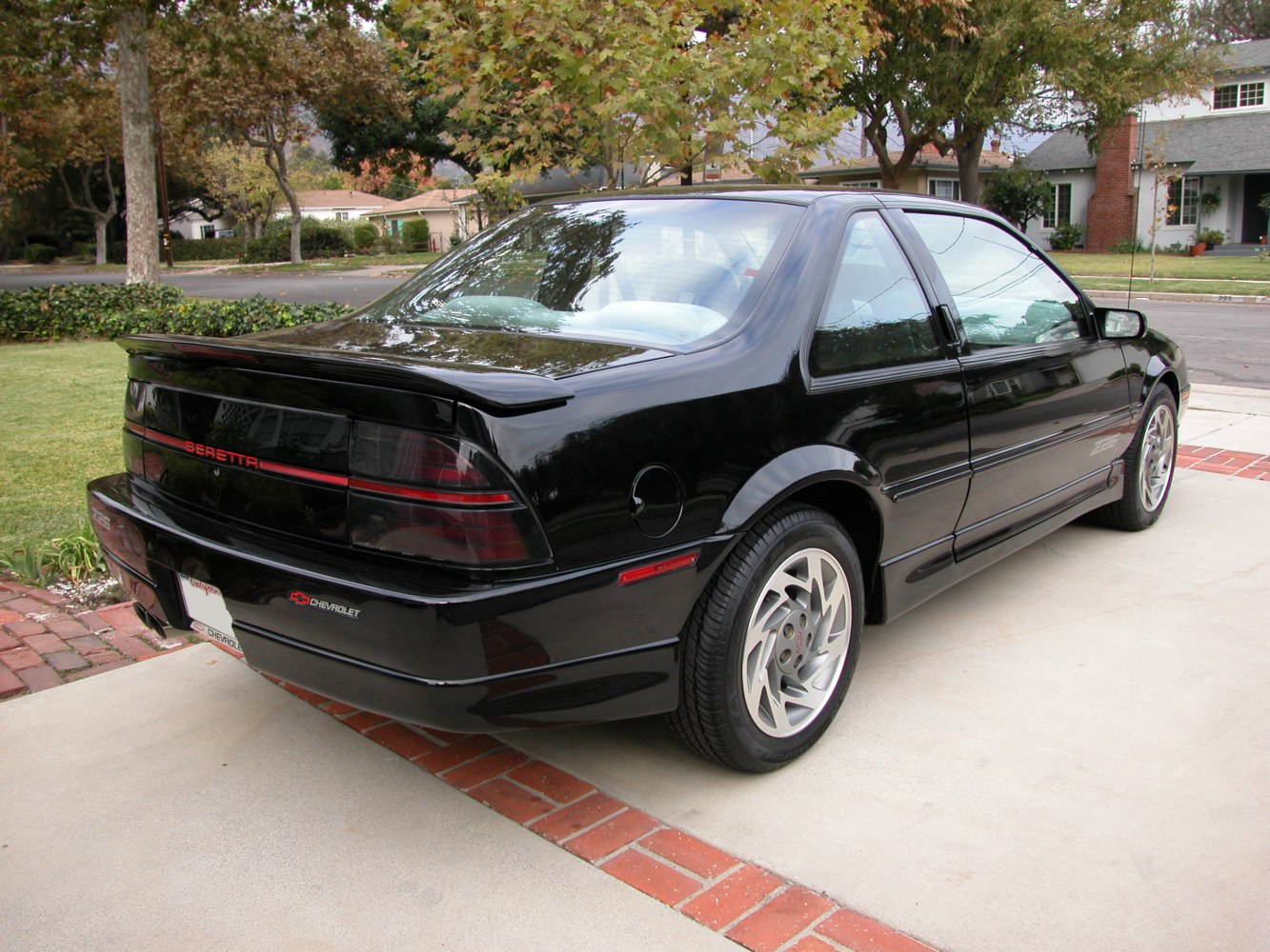 Rear view with tinted tail lights, rear spoiler, and alloy wheels