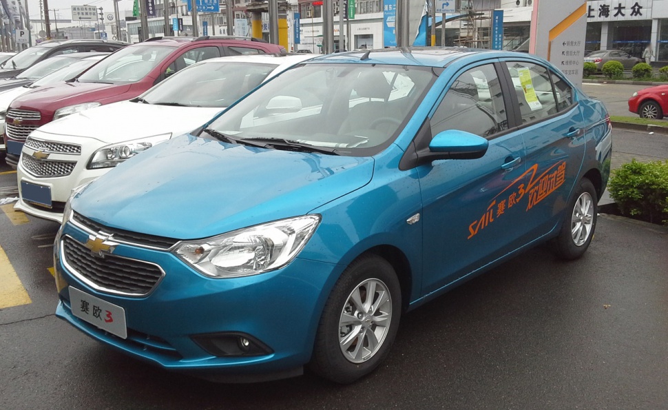 Blue sedan showing front grille and side profile with alloy wheels