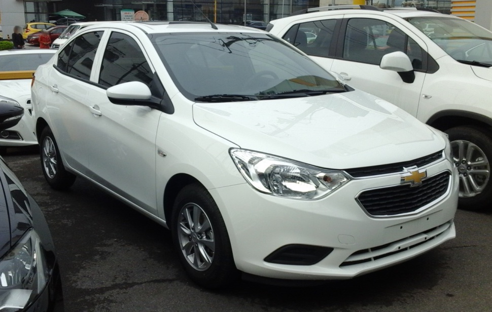White compact sedan with modern headlights and alloy wheels