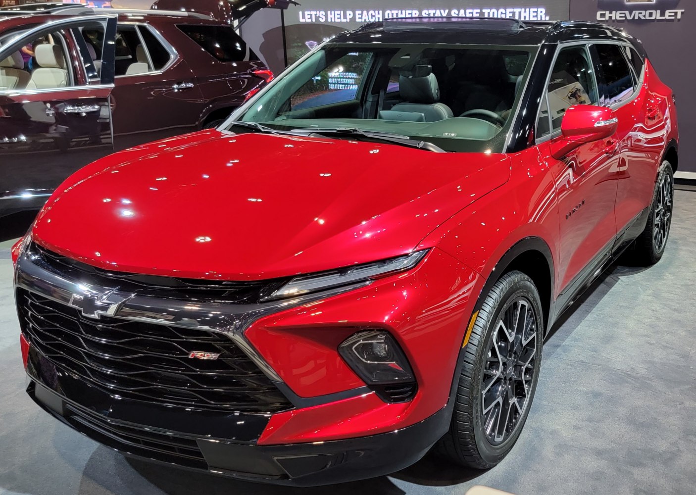 Red SUV front with black grille and LED headlights