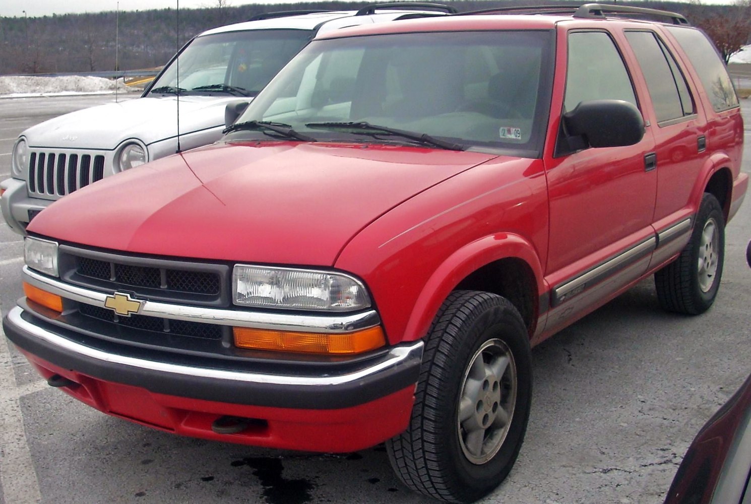 Front view of red SUV with grille, headlights, and wheels