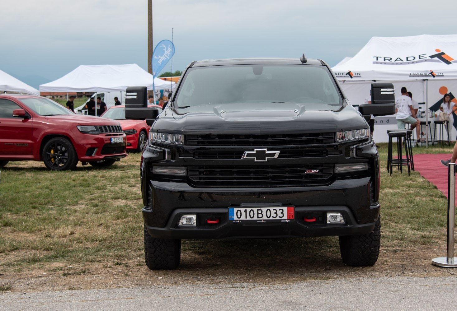 Front view of black truck with bold grille and mirror extensions