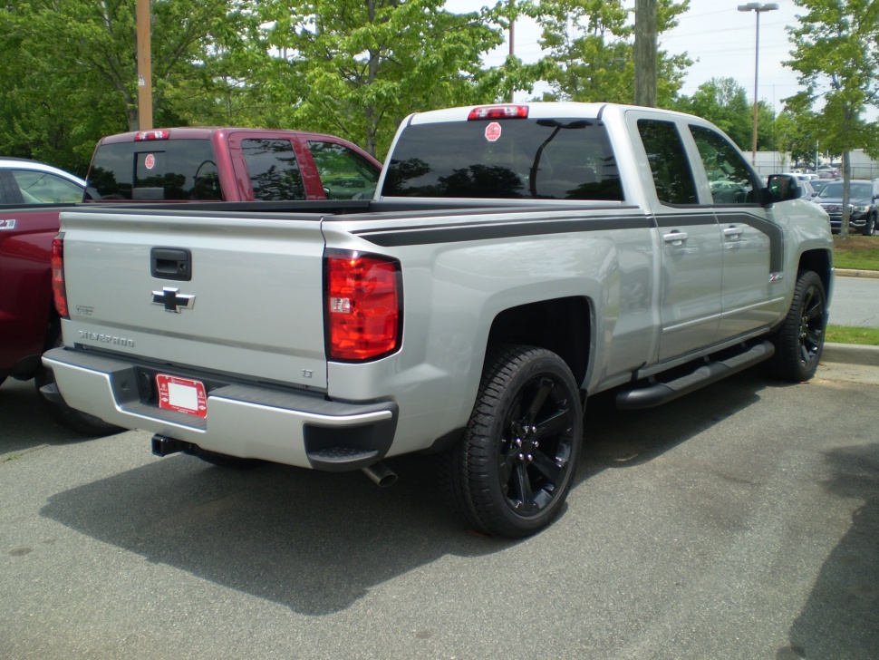 Rear side view of pickup with black wheels and tailgate