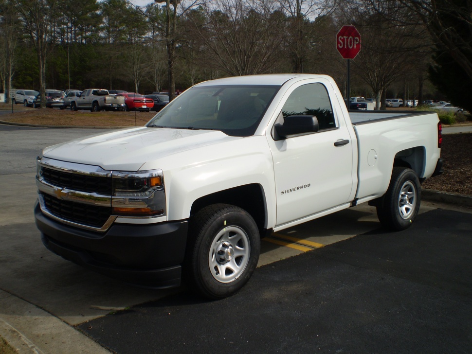 White regular cab pickup truck with chrome grille and black bumper.