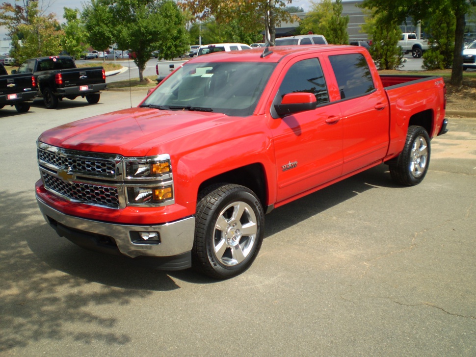 Bright red full-size pickup with chrome grille and alloy wheels