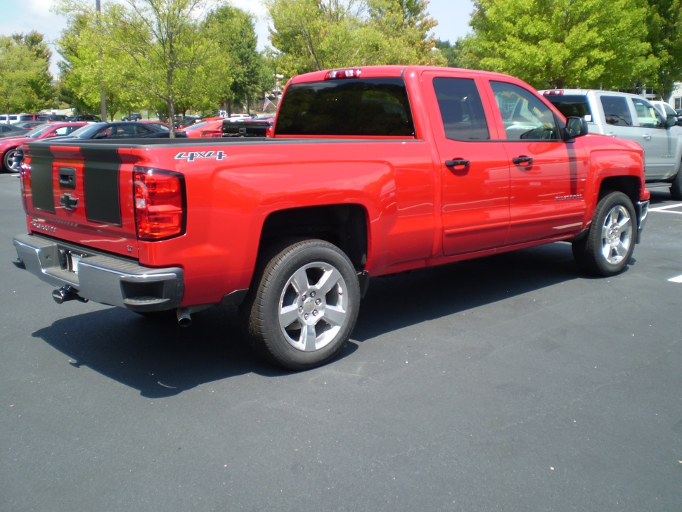 Red double cab pickup truck with 4x4 badge and black tailgate stripes
