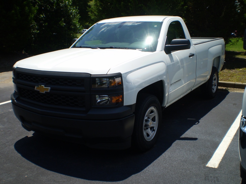 Front and side view of a white regular cab pickup truck with black grille and alloy wheels.