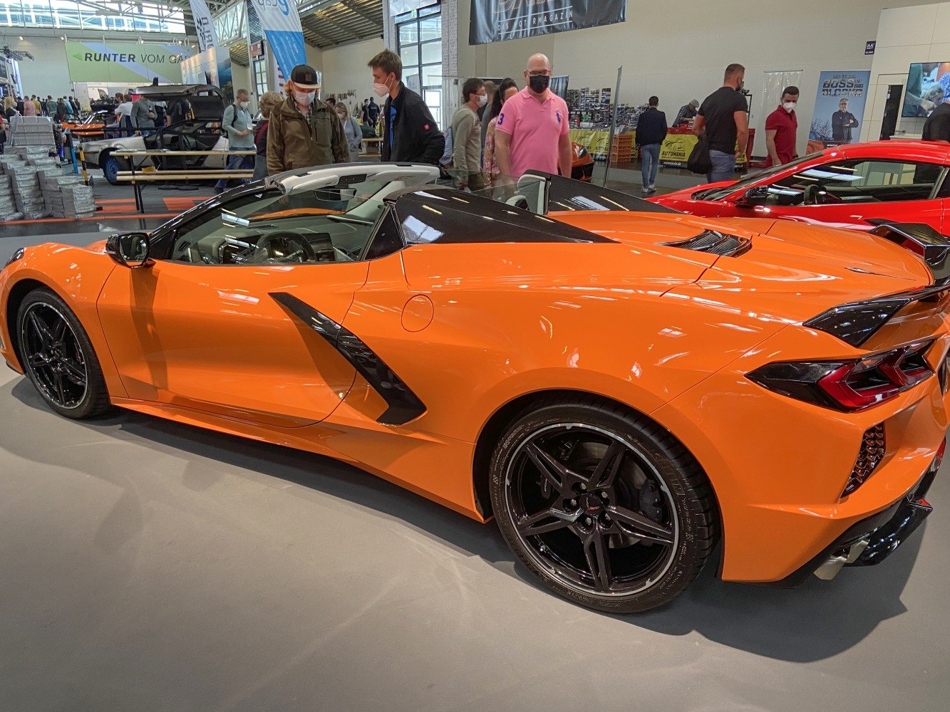 Orange mid-engine sports convertible with black rims and sleek aerodynamic design