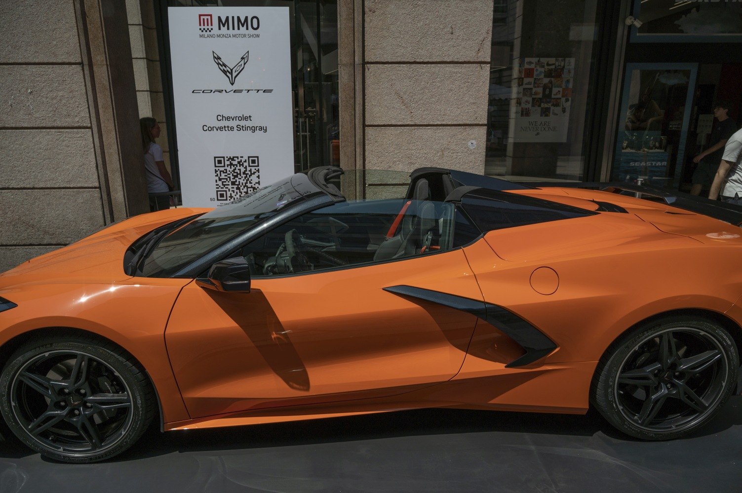 Orange mid-engine convertible with aerodynamic side vents and black wheels.