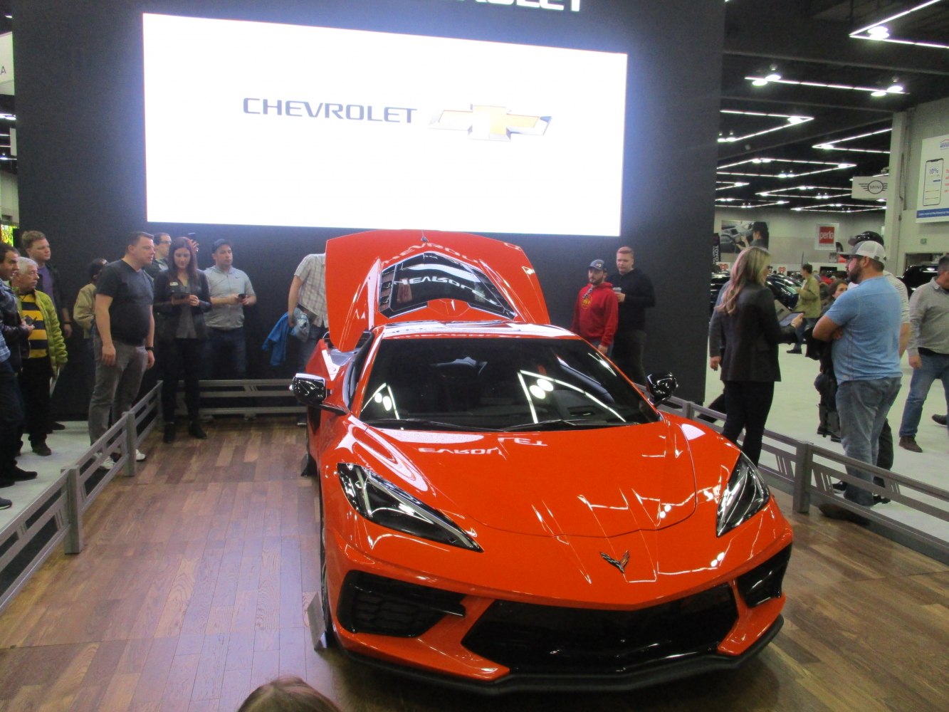 Bright orange sports car front with open engine bay and sharp headlights