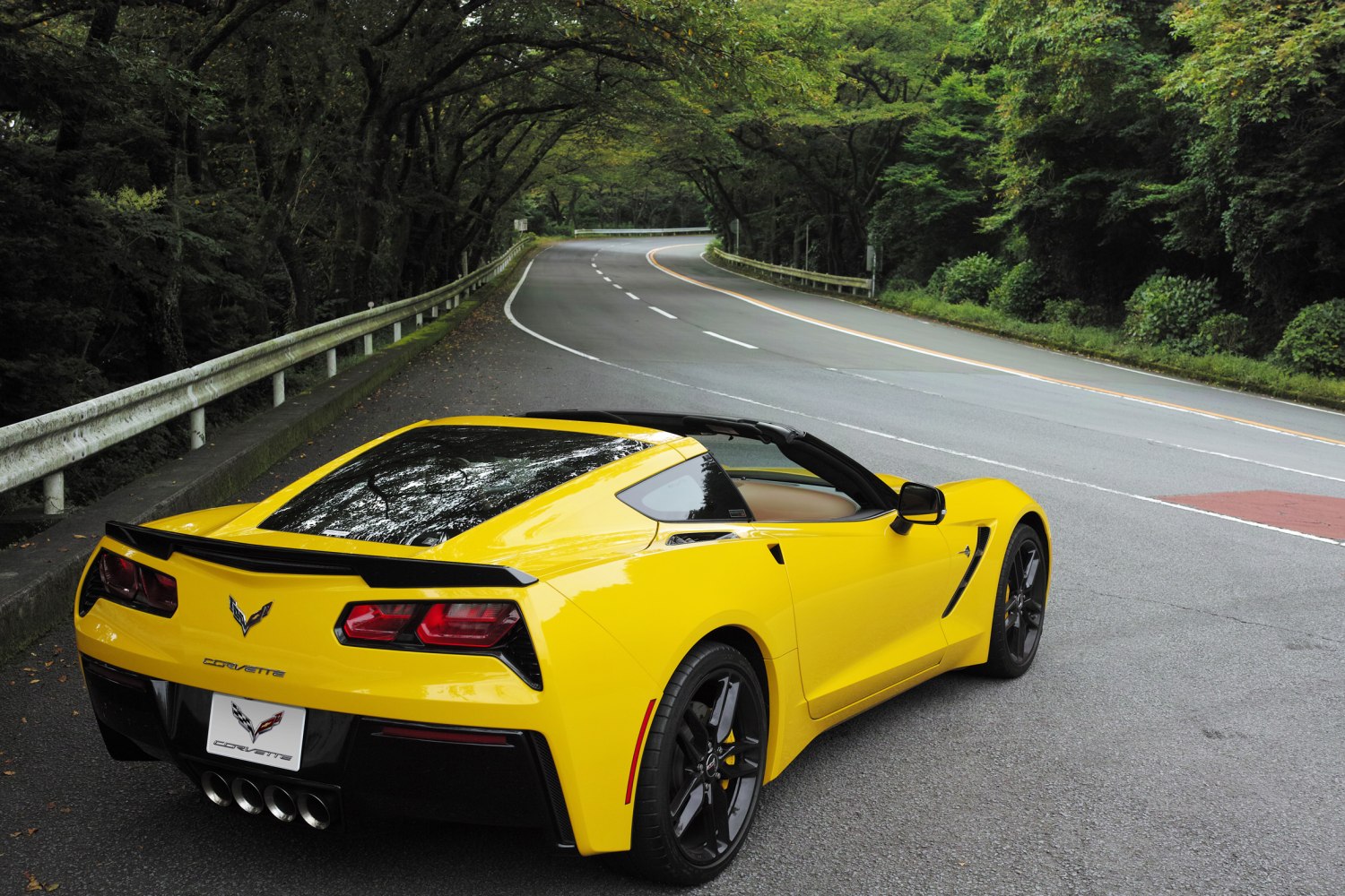 Yellow convertible sports car with targa roof and quad exhaust