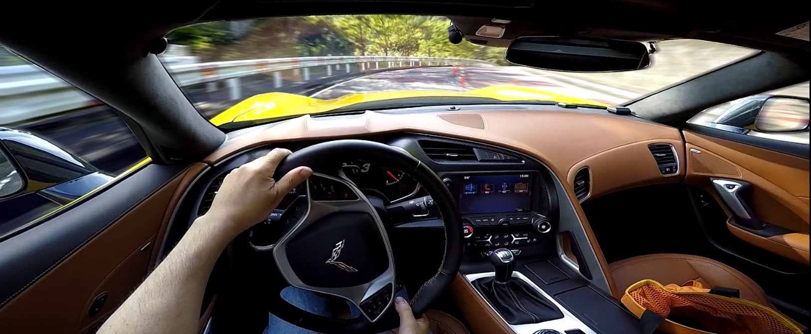 Sporty steering wheel and manual transmission inside a car cockpit