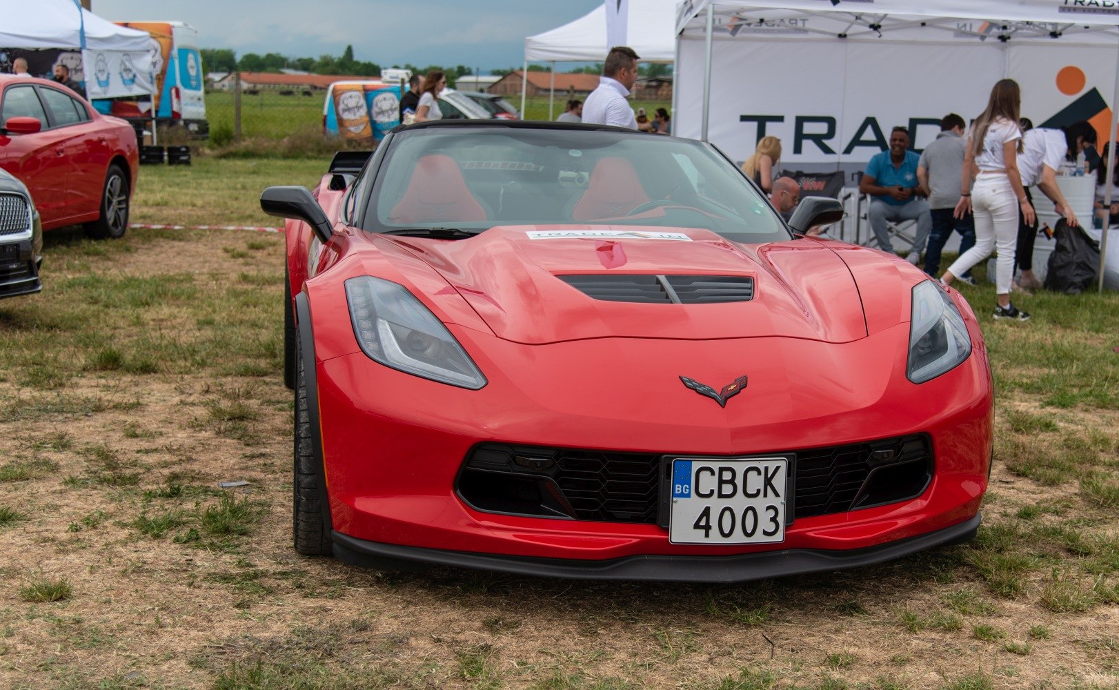 Front view of a red sports car with hood vent and aggressive headlights