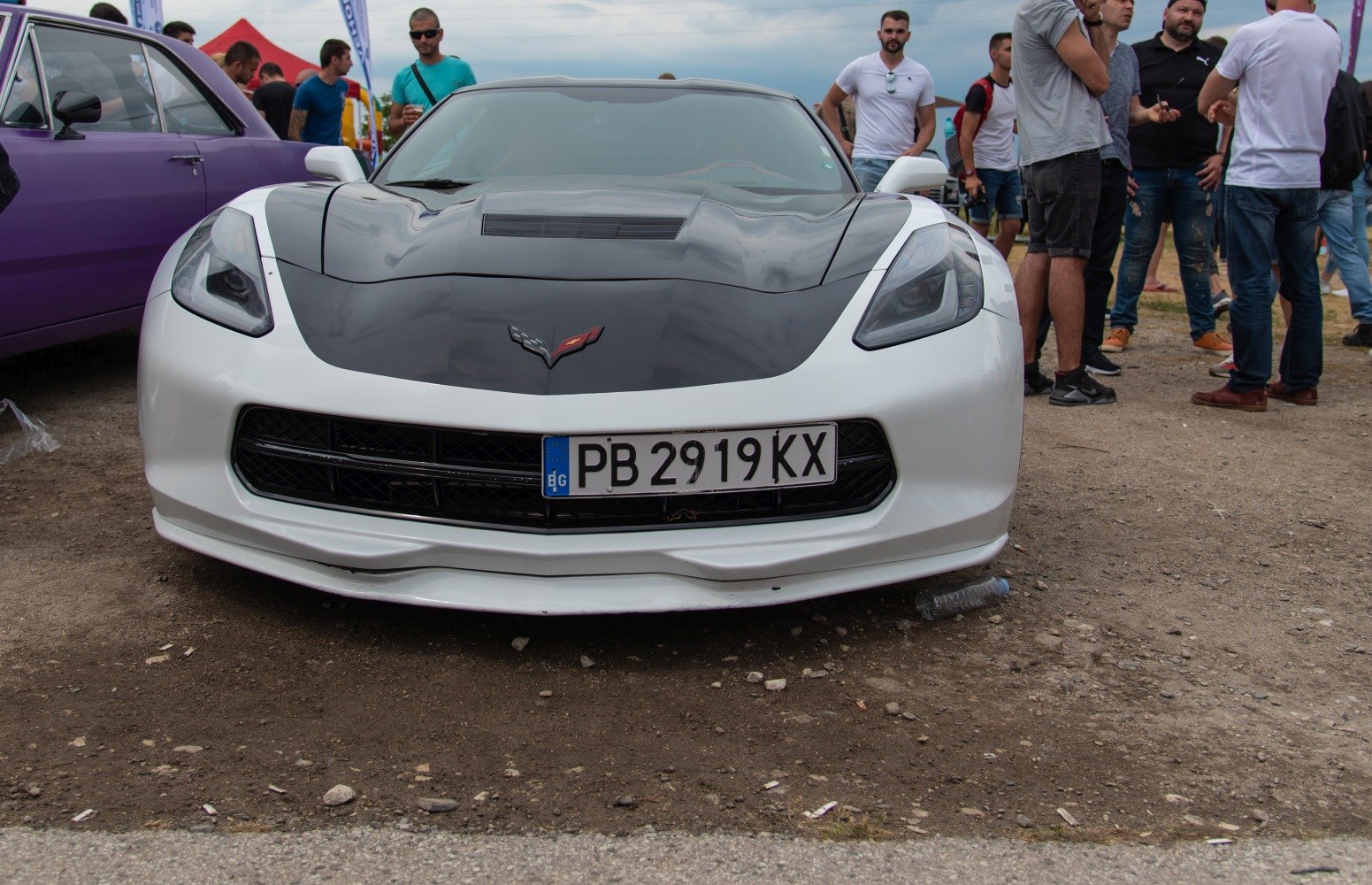 Front view with black hood, aggressive headlights, and sport grille