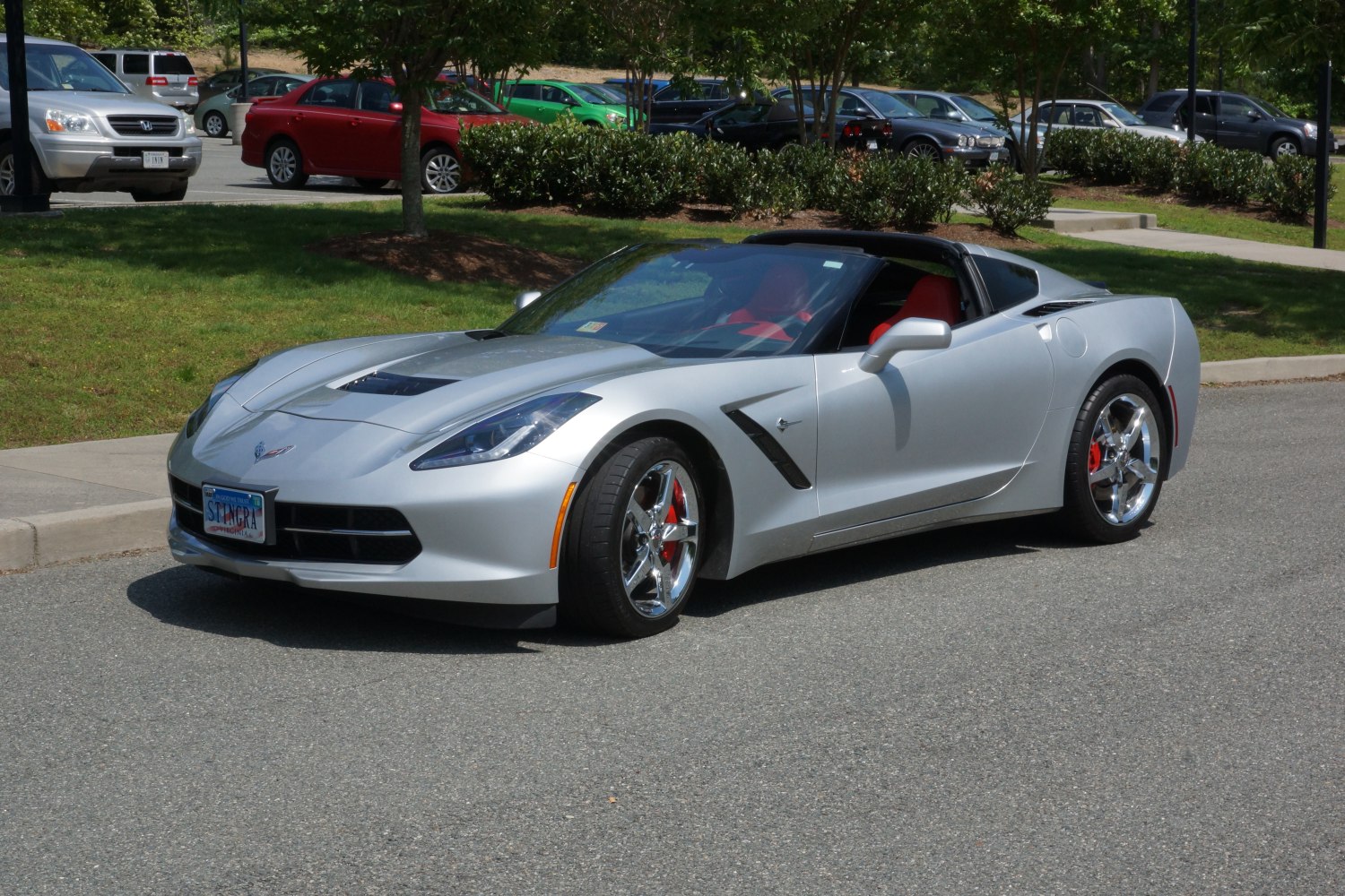 Silver convertible coupe with chrome wheels and red interior