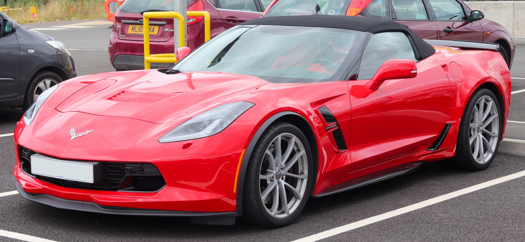 Red convertible with soft top, aerodynamic shape, and alloy wheels