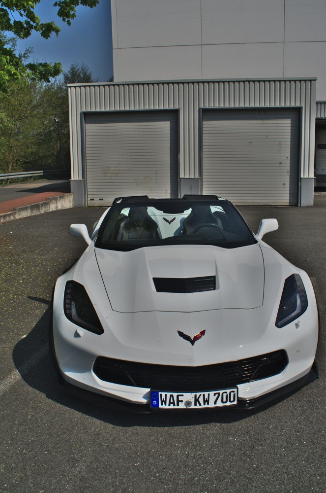 Front view of a white convertible with hood vent and twin seats