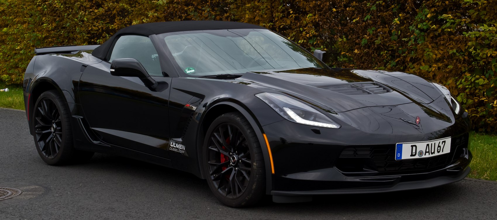 Black convertible sports car with soft top and sharp headlights