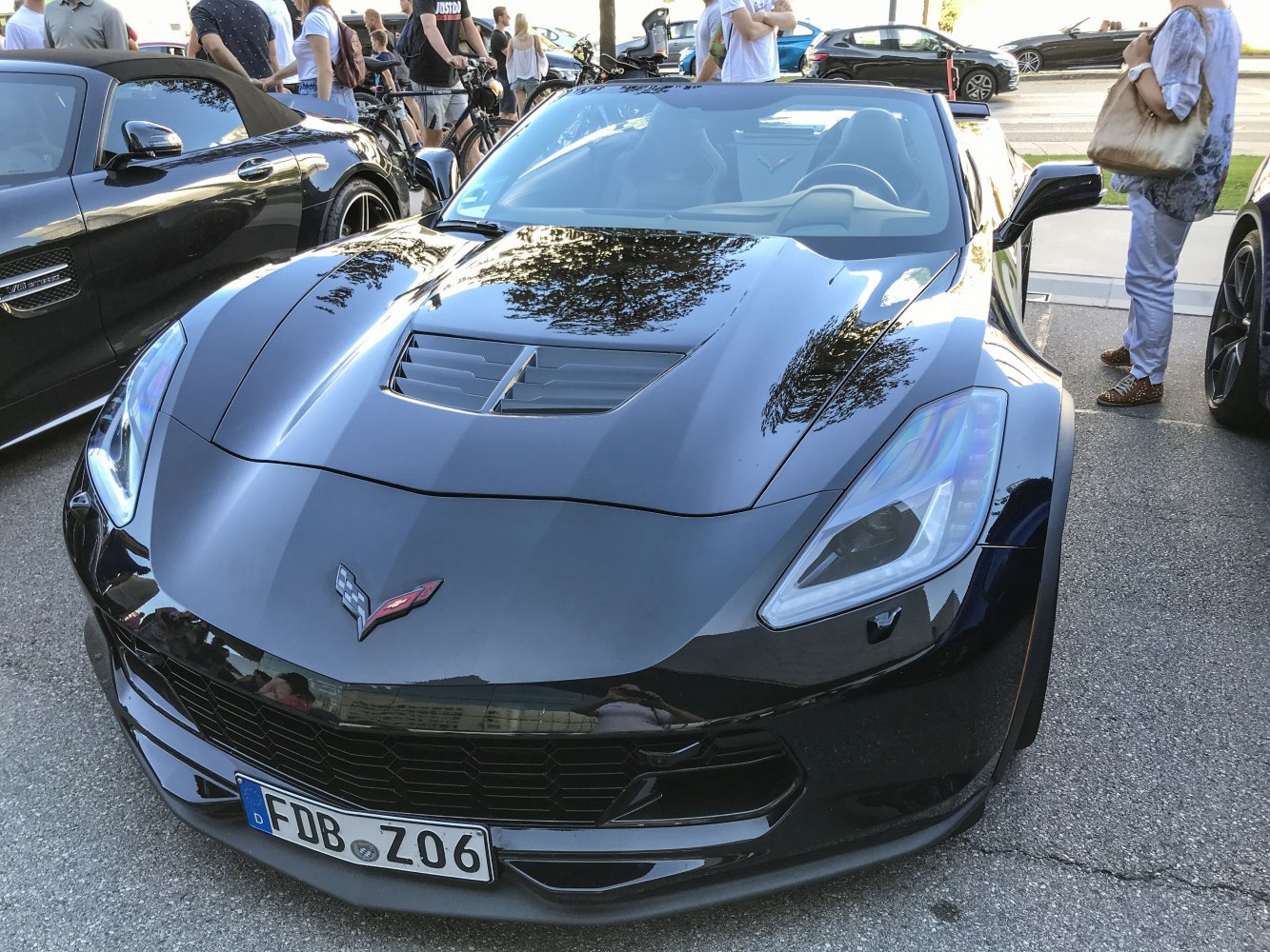 Front view of a sleek convertible sports car with hood vent and sharp headlamps