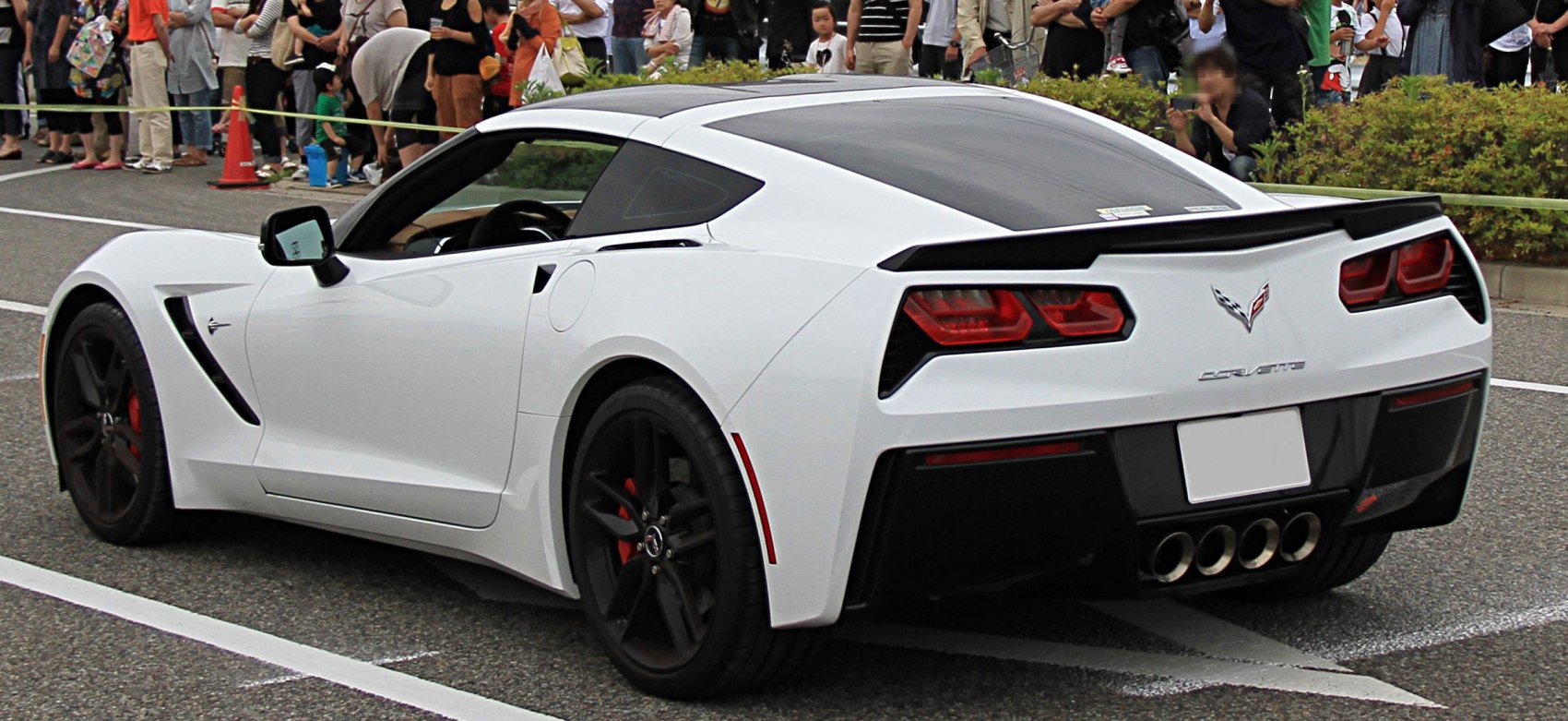 Rear side view of a white coupe with quad exhaust and aerodynamic tail lights