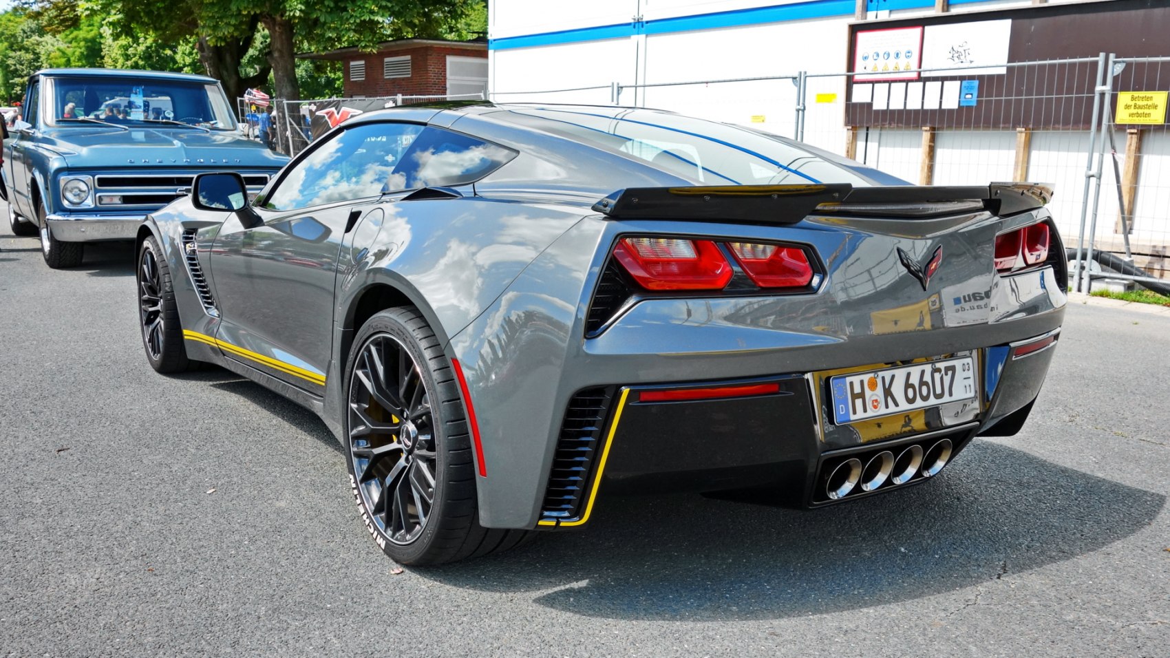 Rear and side perspective of a sports coupe with quad exhaust and black alloy wheels.
