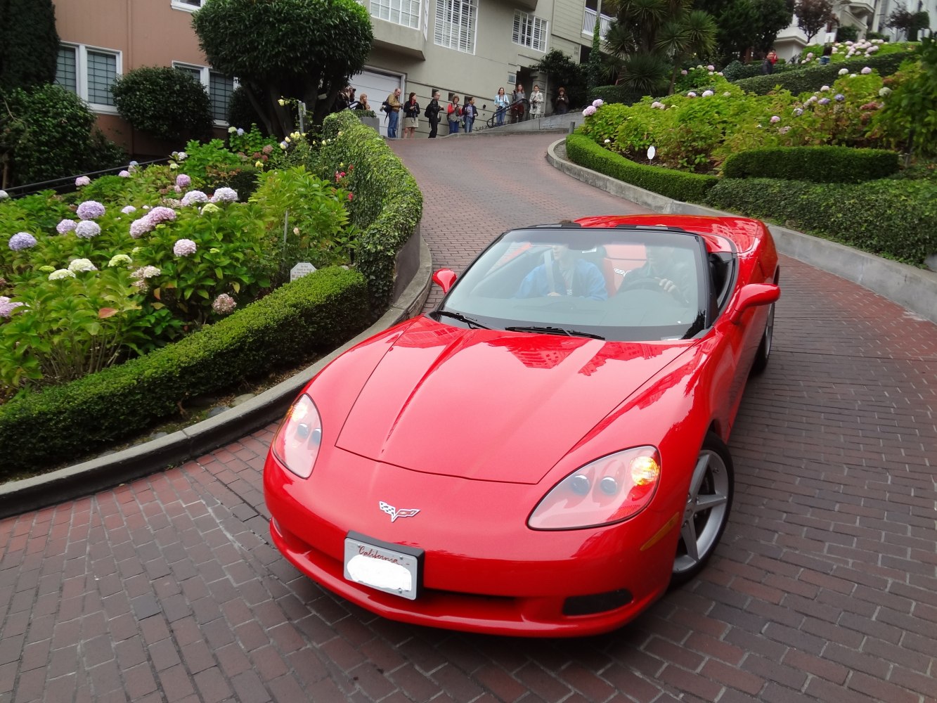 Red convertible sports car front with open roof and sleek hood