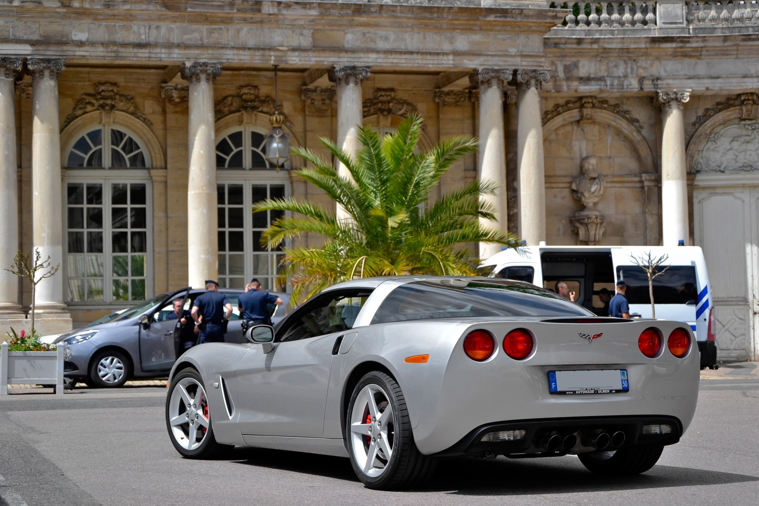 Silver sports coupe rear with quad round taillights and alloy wheels.