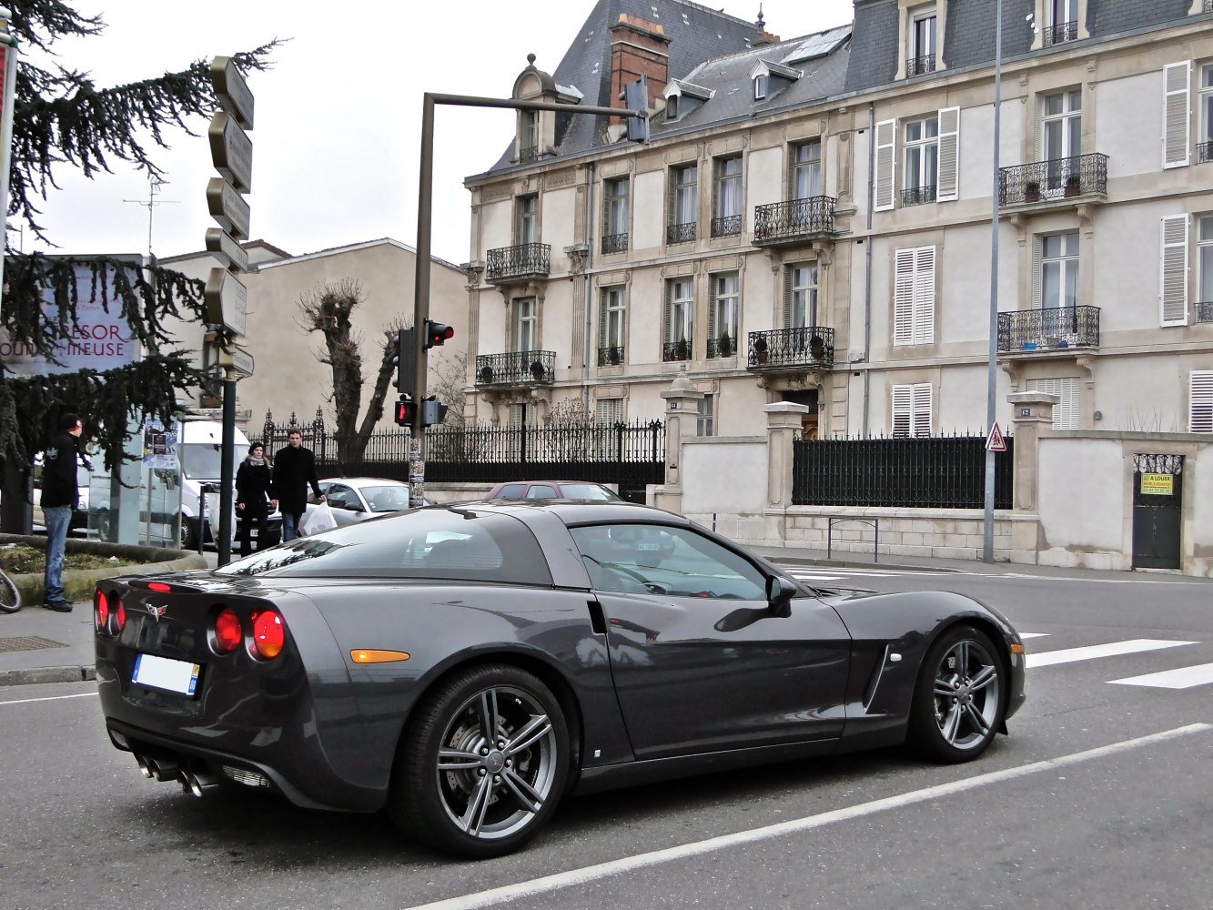 Rear-side view of a sleek sports coupe with distinctive round taillights and aerodynamic design.
