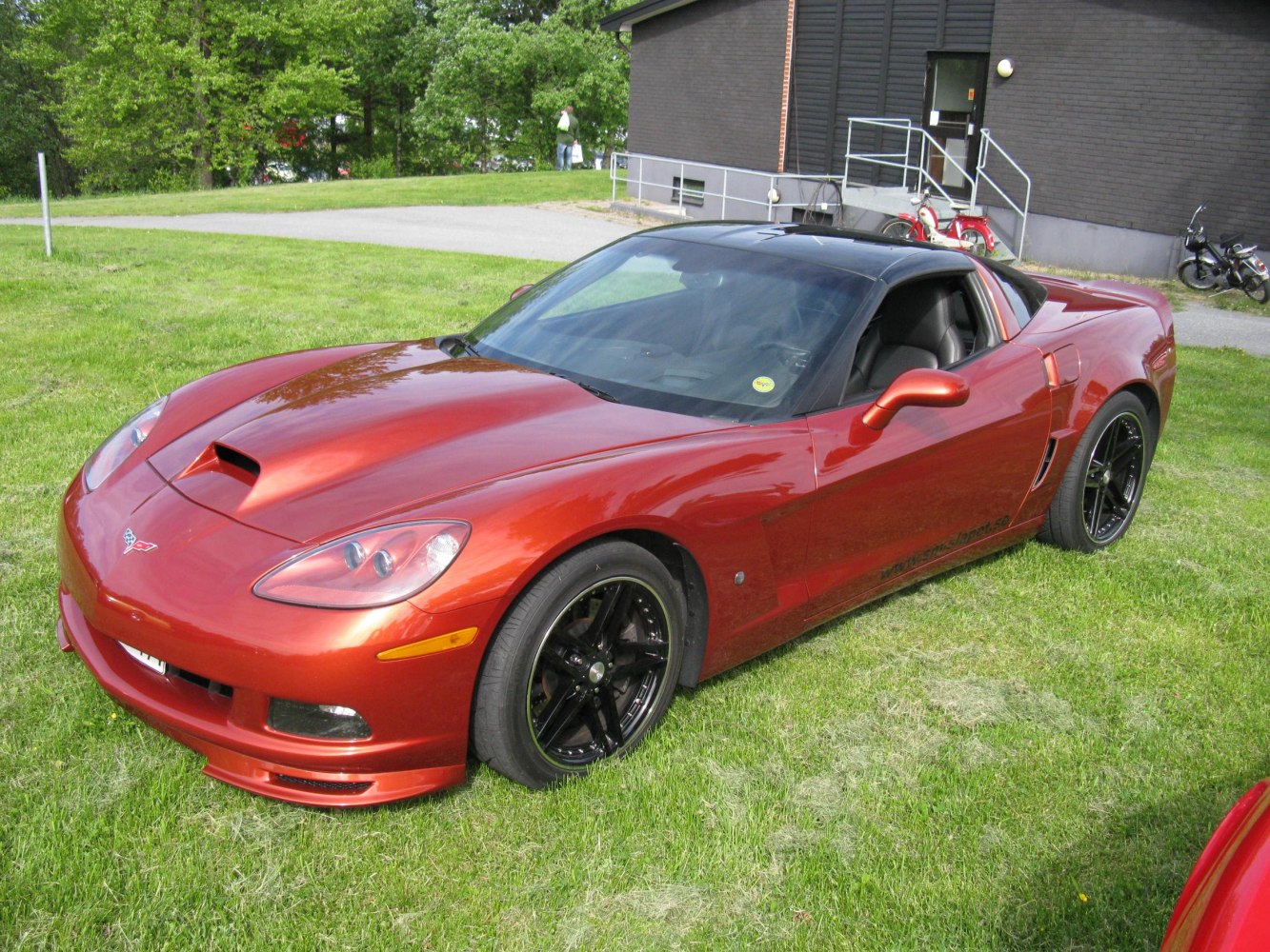 Red sports coupe with hood scoop and black wheels