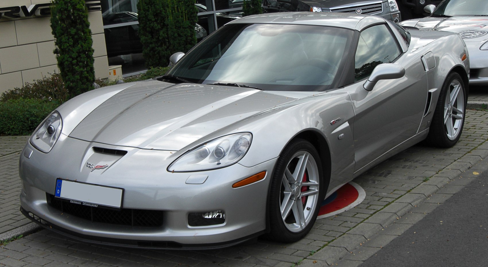 Silver Chevrolet Corvette C6 Coupe front side view with headlights and alloy wheels