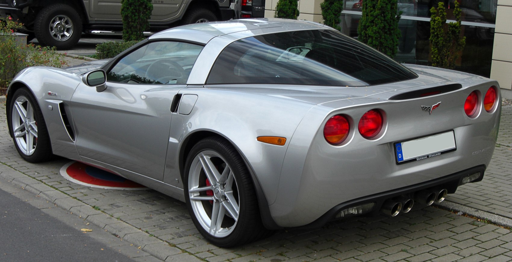 Silver Corvette C6 rear-side with quad exhausts and round taillights