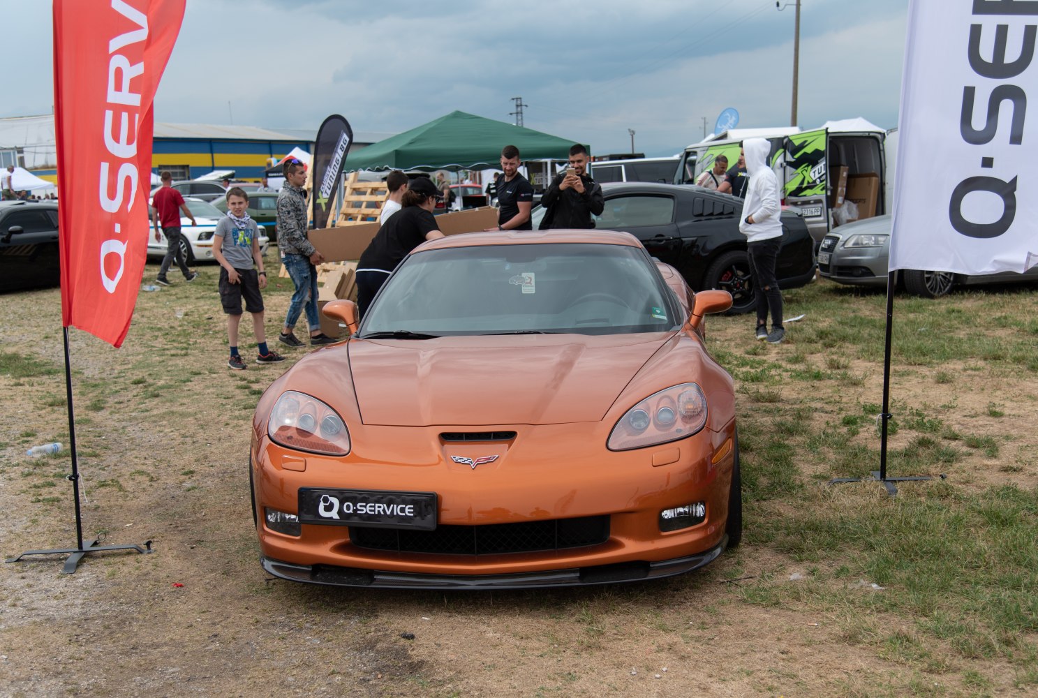 Front view of orange sports coupe with distinctive headlights and central hood vent