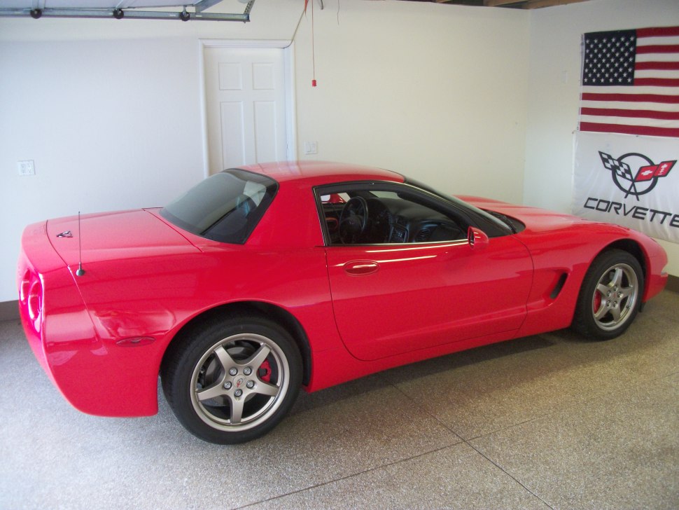 Red sports car side and rear profile with hard top and sporty wheels